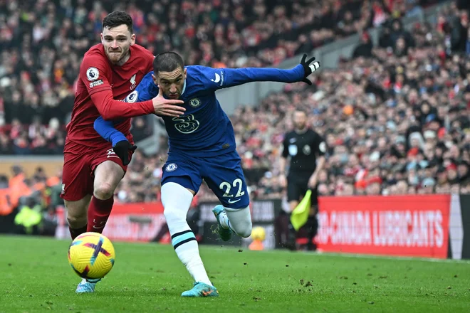 Takole sta se borila za žogo Andrew Robertson in Hakim Ziyech. FOTO: Paul Ellis/AFP
