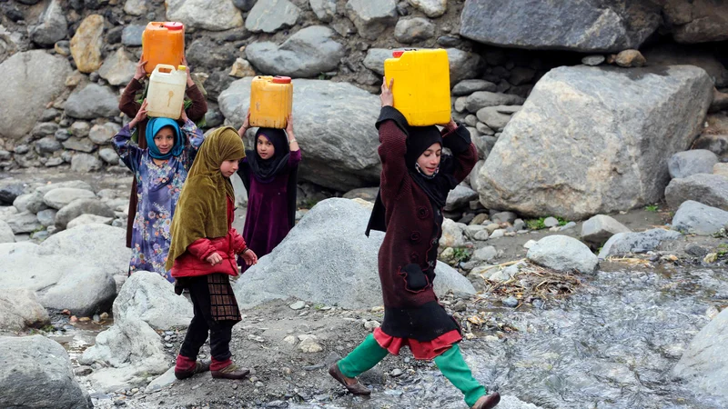 Fotografija: Afganistanska dekleta nosijo kanistre s pitno vodo, ki so jo napolnile iz potoka v okrožju Dara-i-Nur v provinci Nangarhar. Foto: Shafiullah Kakar/Afp