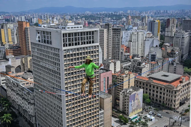 Brazilski vrvohodec Rafael Bridi je v okviru 469. obletnice mesta Sao Paulo na 114 metrih višine po vrvi prečkal celotno 510 metrov dolgo območje Vale do Anhangabau. Bridi je po podatkih mednarodnega združenja za »slackline« podrl svoj lastni rekord na urbani razdalji. Foto: Nelson Almeida/Afp