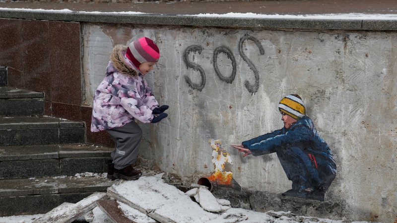 Fotografija: Štiriletna Anastazija stoji ob umetniškem delu znanega uličnega umetnika Tvboya v središču Buče, ki se nahaja blizu Kijeva. Foto: Valentyn Ogirenko Reuters

