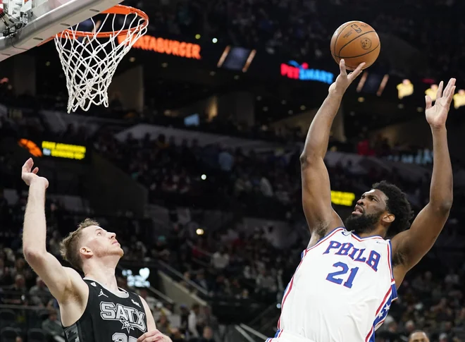 Philadelphiiin Kamerunec Joel Embiid je bil v San Antoniu nerešeljiva uganka za domačega Avstrijca Jakoba Pötla. FOTO: Scott Wachter/Usa Today Sports
