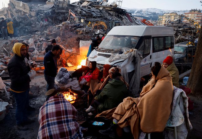 Ljudje poleg uničenih stavb v Kahramanmaraşu. FOTO: Suhaib Salem/Reuters

