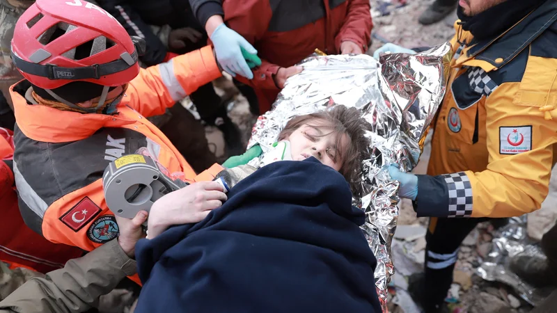 Turškega dečka jim je uspelo potegniti izpod ruševin. FOTO: Stringer Reuters