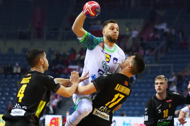 Aleks Vlah (z žogo) med nastopom na letošnjem svetovnem prvenstvu v obračunu s Črnogorci. FOTO: Kacper Pempel/Reuters
