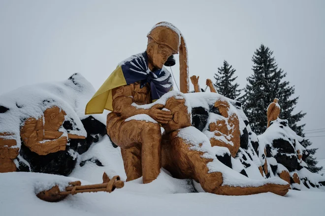 Spominska skulptura, pokrita z ukrajinsko zastavo. Boljši bi bili opomniki na mir.&nbsp;FOTO: Yasuyoshi Chiba/AFP
