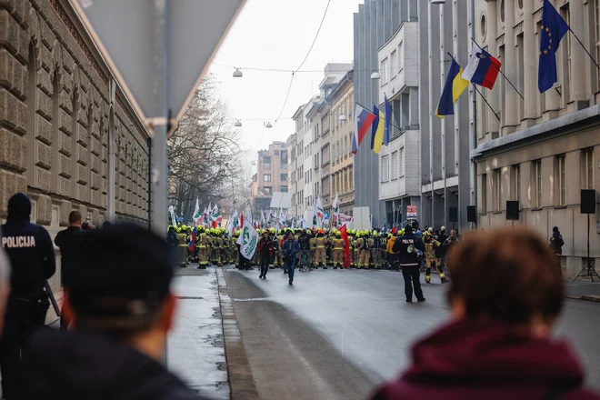 Ob protestu gasilcev policisti niso imeli niti varovalne opreme, le volnene kape, da so jih varovale pred mrazom. FOTO: Črt Piksi