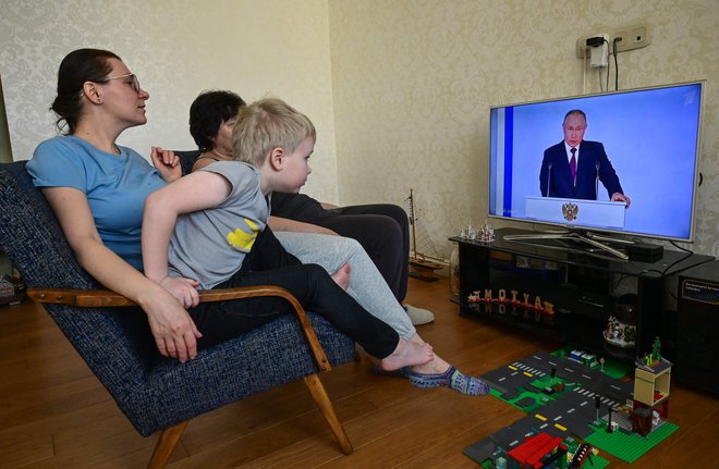 Družina gleda prenos govora ruskega predsednika. FOTO: Yuri Kadobnov/AFP
