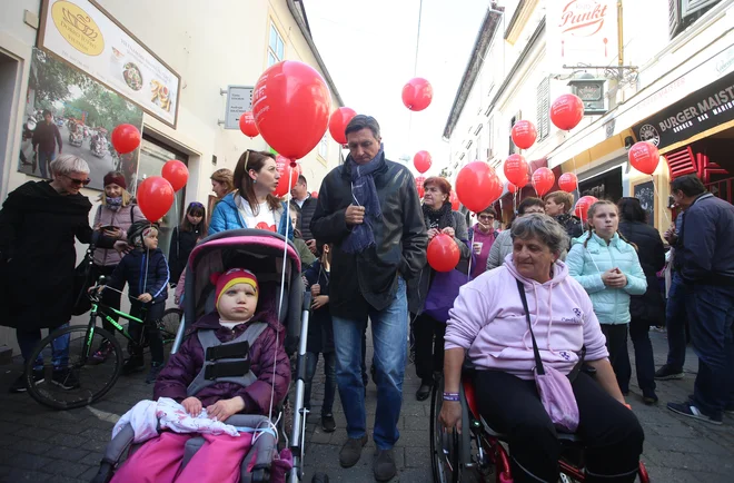 Z rdečimi baloni proti predsodkom o obolelih z redkimi boleznimi. FOTO: Tadej Regent/Delo
