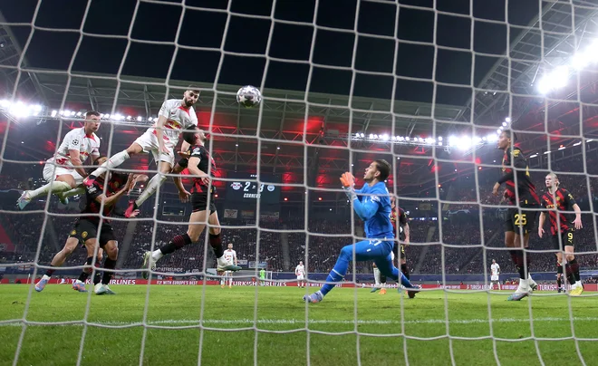Joško Gvardiol je z glavo izenačil za Leipzig proti Manchester Cityju. FOTO: Ronny Hartmann/AFP
