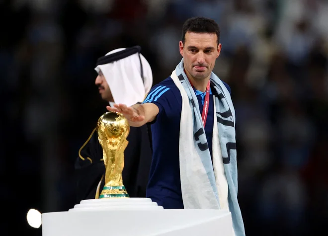 Lionel Scaloni s pokalom za naslov svetovnega prvaka, preden ga je visoko v zrak po zmagi v finalu nad Francijo dvignil kapetan Lionel Messi.&nbsp;FOTO: Hannah Mckay/Reuters
