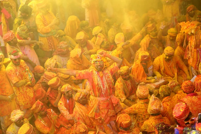 Indijski verniki se obmetavajo z barvami med praznovanjem hindujskega spomladanskega praznika Holi v templju Shreeji v Barsani. Foto: Afp