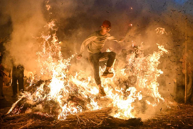 Moški skače čez ogenj, da bi se po starem običaju znebil nesreče v mestu Jieyang v južni kitajski provinci Guangdong. Foto: Stringer/Afp