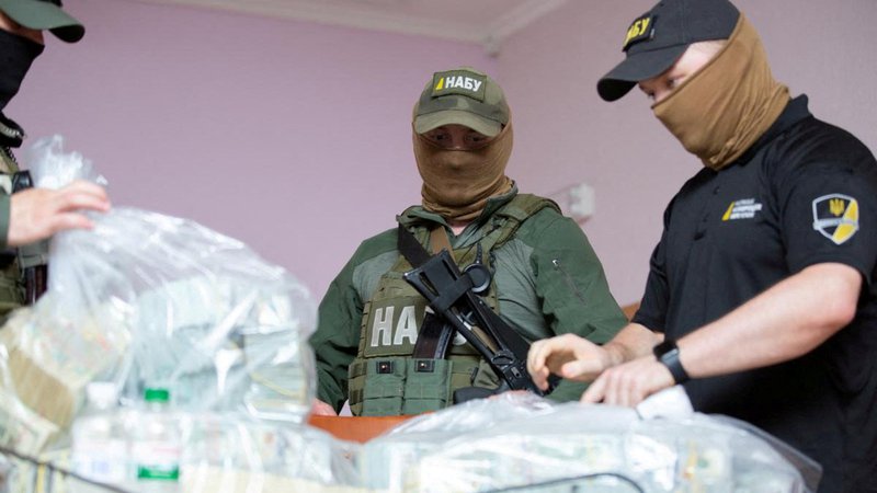 Fotografija: Policisti z zaseženim denarjem iz korupcijskih dejanj. FOTO: Reuters
