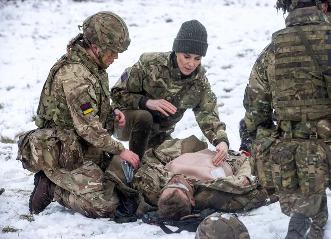 Britanska princesa Catherine se je med obiskom 1. bataljona irske garde na vadišču v bližini Salisburyja, na jugu Anglije, preizkusila v urjenju o oskrbi poškodovanih vojakov med simulacijo nesreče. Foto: Steve Reigate/Afp