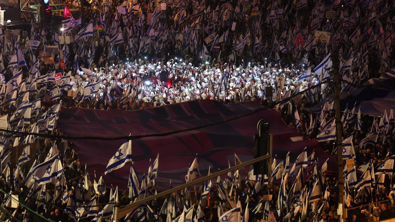Fotografija: Protest v Tel Avivu. Cilj sporne reforme je povečanje moči parlamenta in znatna omejitev možnosti vrhovnega sodišča, da razveljavi zakone in vladne odločitve. Z njo želijo vladi zagotoviti tudi nadzor nad imenovanjem vrhovnih sodnikov. FOTO: Jack Guez/AFP

