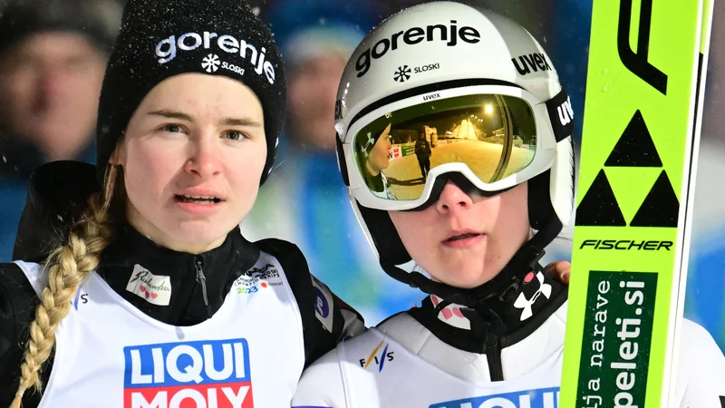 Fotografija: Nika Križnar (levo) in Ema Klinec že radovedno pogledujeta proti letalnici v Vikersundu. FOTO: Jure Makovec/AFP