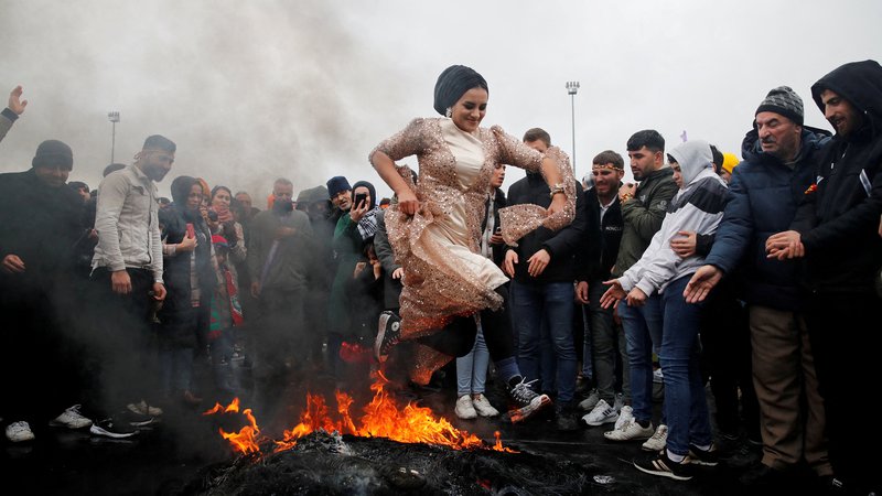 Fotografija: Ženska skače čez ogenj v Istanbulu med praznovanjem praznika Nowruz, ki zaznamuje prihod pomladi. Foto: Dilara Senkaya/Reuters
