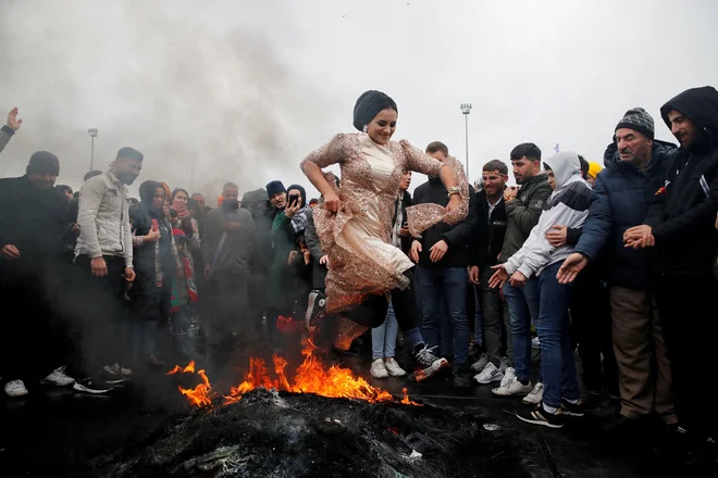Ženska skače čez ogenj v Istanbulu med praznovanjem praznika Nowruz, ki zaznamuje prihod pomladi. Foto: Dilara Senkaya/Reuters