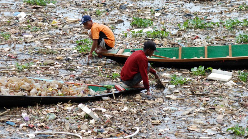 Fotografija: Smetarja na čolnih zbirata plastiko v izredno onesnaženi reki Citarum v Bandungu na zahodu indonezijskega otoka Java. Foto: Timur Matahari/Afp
