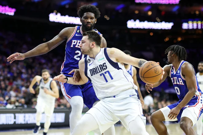 Luka Dončić je izgubil bitko z donedavnim tekmecem za naslov najboljšega košarkarja sezone Joelom Embiidom (za njim). FOTO: Tim Nwachukwu/AFP