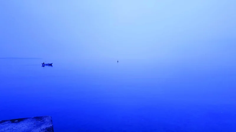 Fotografija: Megla s svojo neskončnostjo, kjer se horizont zamegli in ni več jasne ločnice med ravnino morja in širino neba, bolj ali manj vse postane sivina ali modrina, ki pa jo kot detajl osredotoča ribiški čoln.
V Piranu pozimi 2022.
FOTO (in opis iz knjige): Robert Potokar