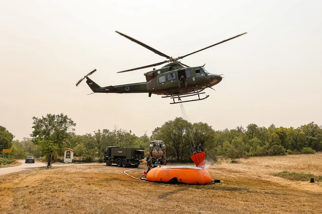 Helikopter med zajemanjem vode julija lani. FOTO: Črt Piksi/Delo