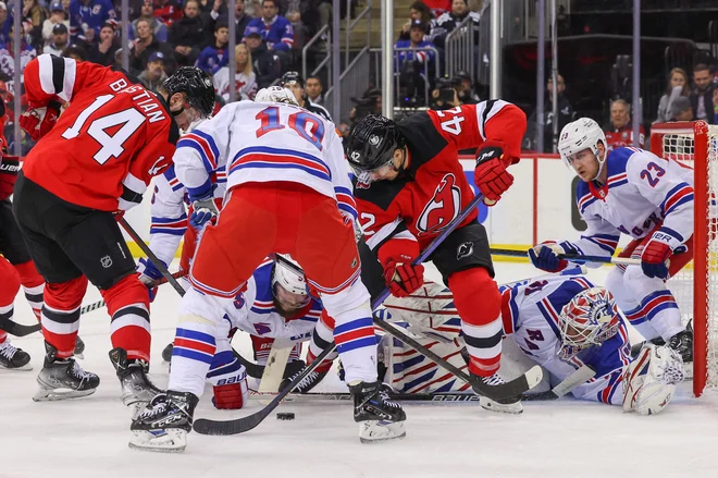 Hokejiste New Jerseyja (v rdečih dresih) v lokalnem derbiju proti New York Ranegers le še zmaga loči od napredovanja. FOTO: Ed Mulholland/Usa Today Sports/Reuters