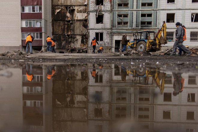 Odstranjevanje materiala poškodovane stanovanjske zgradbe po včerajšnjem ruskem raketnem napadu v mestu Uman na območju Čerkaškega okrožja. FOTO: Carlos Barria/Reuters