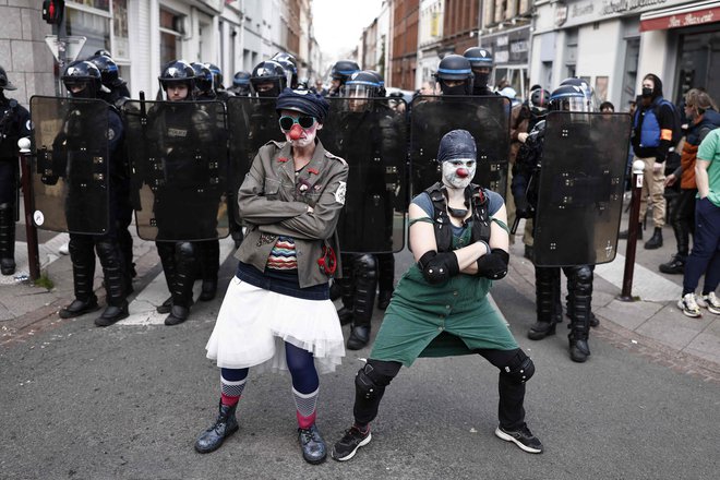 Protestniki, oblečeni v klovne, plešejo pred francosko policijo med demonstracijam ob prazniku dela. FOTO: AFP