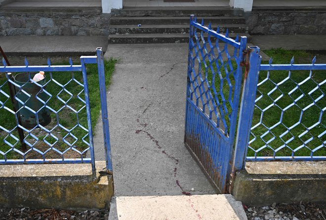 Sledi krvi ob šolskem igrišču v vasi Dubona, kjer se je tragični dogodek domnevno začel s sporom. FOTO: Andrej Isakovic/AFP
