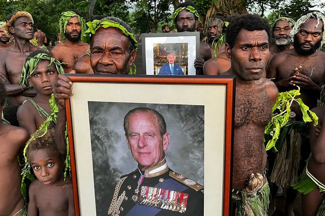 Vaščani na otoku Tanna v Vanuatuju s slikami članov kraljeve družine. FOTO: Ben Bohane/AFP

 