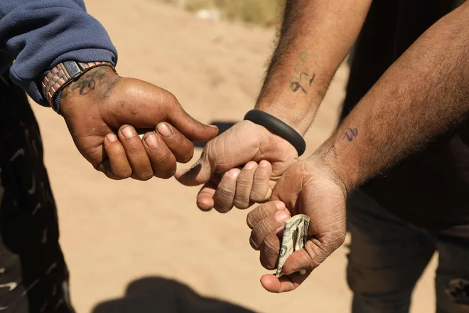 Po prečkanju meje iz Ciudad Juareza v Mehiki venezuelski migranti kažejo številke, označene na zapestju, da bi se razvrstili v obdelavi mejne patrulje v sektorju El Paso v Teksasu. Mehiški predsednik Andres Manuel Lopez Obrador je v ponedeljek dejal, da se bo pred odpravo mejnih omejitev iz časa pandemije ta teden o migracijski politiki pogovarjal s svojim ameriškim kolegom Joejem Bidenom. Foto: Herika Martinez/Afp