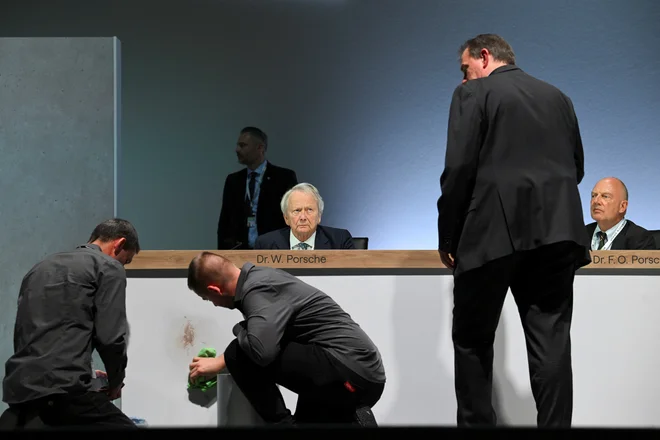 Aktivisti so prekinili letno skupščino koncerna Volksegan Med govorom predsednika nadzornega sveta Dieterja Pötscha je v smeri Wolfganga Porscheja, predstavnika družine, ki je glavni  lastnik, poletela torta. FOTO: Annegret Hilse Reuters