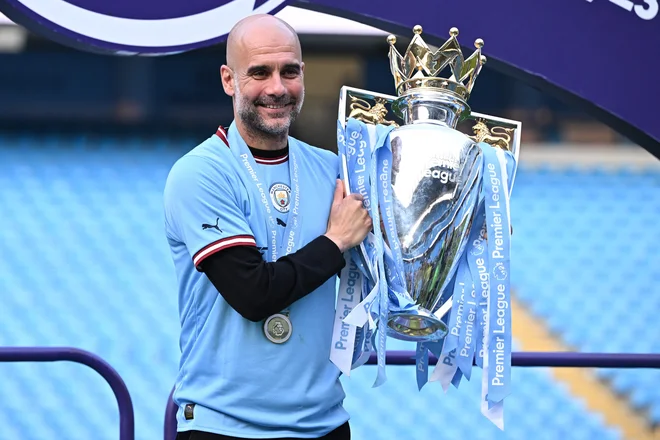 Takole je Pep Guardiola poziral s pokalom za naslov angleškega nogometnega prvaka. FOTO: Oli Scarff/AFP