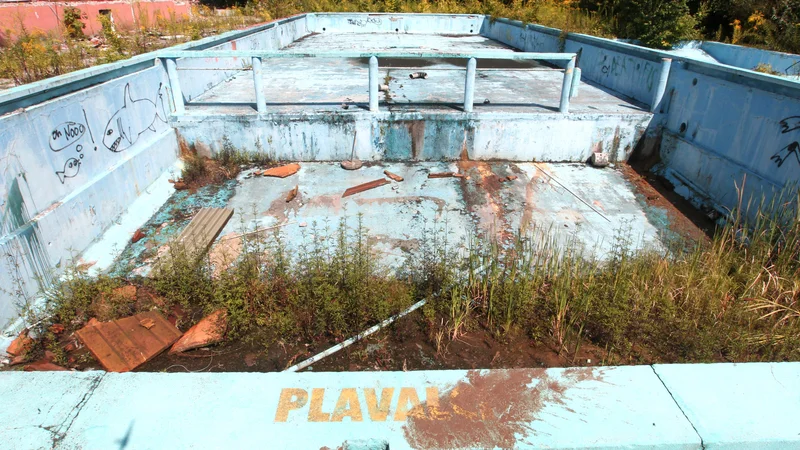 Fotografija: Namesto vode v vevškem kopališču raste plevel. In tako bo vsaj še tri leta, dokler ne bodo uredili odprtega kopališča in športnega kompleksa. FOTO: Dejan Javornik/Delo