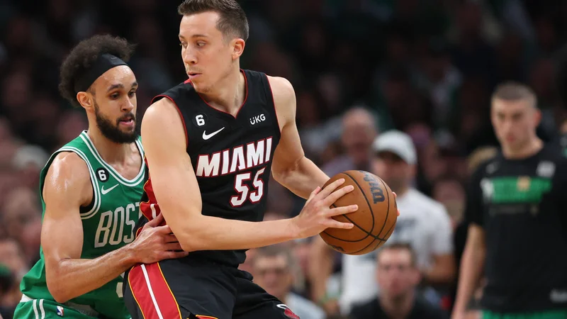 Miamijev najboljši strelec Duncan Robinson (desno) je bil premalo za razigrane Bostonove tekmece, med katerimi je bil prvi mož Derrick White (levo). FOTO: Maddie Meyer/AFP