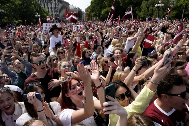 Tako vzneseno je množica v Rigi včeraj pričakala svoje hokejske junake. Vlada pa je za ta ponedeljek razglasila državni praznik.FOTO: Ints Kalnins/Reuters