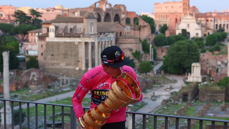 Fotografija: Primož Roglič je bil v nedeljo kralj Rimskega foruma v rožnati majici in z neskončno trofejo Gira. FOTO: Luca Bettini/AFP