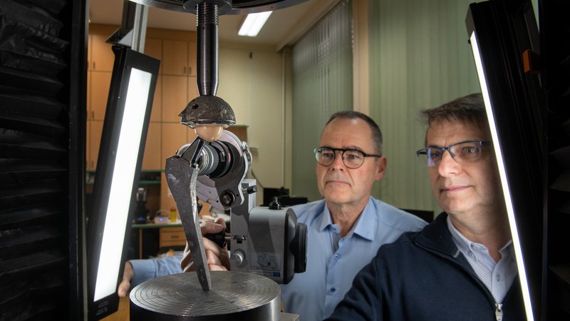 Fotografija: Samo K. Fokter (levo) in Nenad Gubeljak med izvajanjem obremenilnega preizkusa natezne trdnosti izmenljivega vratu. FOTO: arhiv UM

 
