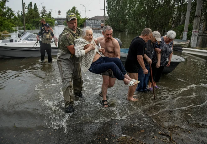Po kolapsu na jezu rešujejo, kogar in kar se rešiti da ... FOTO: Stringer Reuters