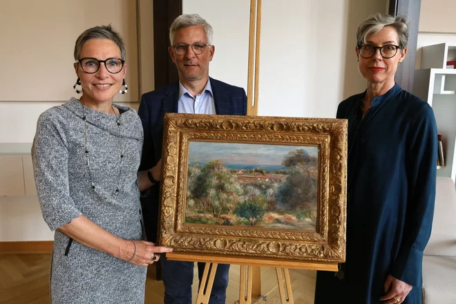 Dolgoletna kustosinja muzeja Osthaus Birgit Schulte, hagenski župan Erik O. Schulz in Stephanie Tasch, vodja zveznega sklada za kulturo, z Renoirjevo krajino, ki bo še naprej razstavljena v stalni zbirki muzeja Osthaus v Hagnu. FOTO: Clara Treude/mesto Hagen