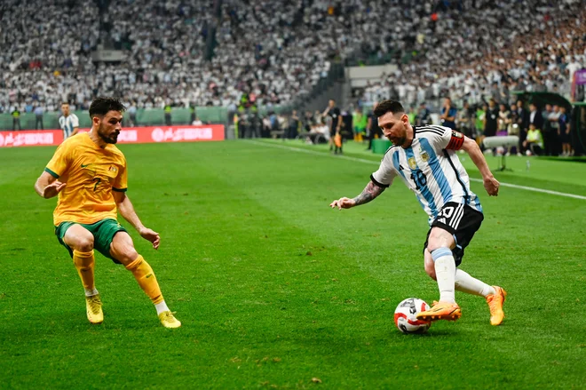 Lionel Messi (desno) in Mathew Leckie med tekmo Argentine in Avstralije. FOTO: Pedro Pardo/AFP