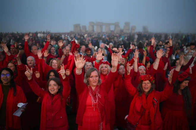 V Stonehengeu, na jugu Anglije, ljudje prepevajo in čakajo na sončni vzhod ob praznovanju festivala poletnega solsticija, ki je star že več tisoč let in časti najdaljši dan v letu. Kamniti spomenik - vklesan in zgrajen v času, ko še ni bilo kovinskih orodij - simbolizira napol mitično prazgodovinsko obdobje v Veliki Britaniji, ki je ustvaril nešteto legend. Foto: Daniel Leal/Afp