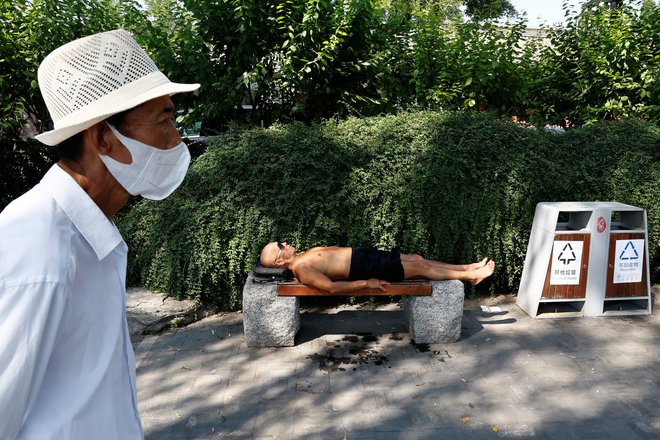 Podobe razgretih Pekinžanov, ki različno resno jemljejo opozorila vremenoslovcev. FOTO: Tingshu Wang/Reuters