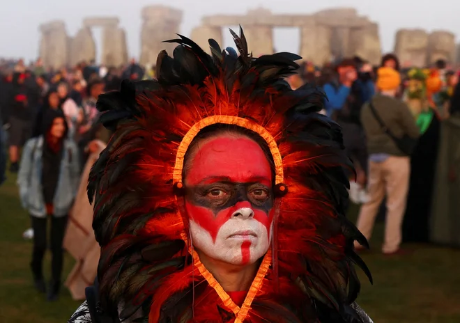 V Stonehengeu, na jugu Anglije so ljudje prepevali in čakali na sončni vzhod ob praznovanju festivala poletnega solsticija, ki je star že več tisoč let in časti najdaljši dan v letu. Kamniti spomenik - vklesan in zgrajen v času, ko še ni bilo kovinskih orodij - simbolizira napol mitično prazgodovinsko obdobje v Veliki Britaniji, ki je ustvaril nešteto legend. Foto: Toby Melville/Reuters