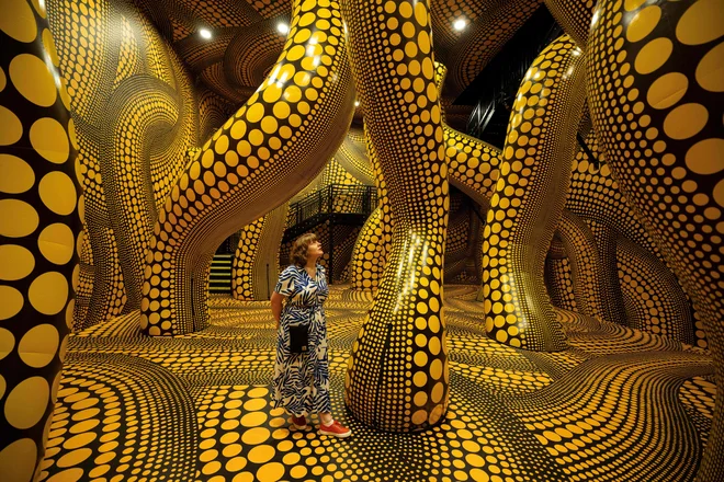 Ženska občuduje umetniško delo z naslovom »Upanje na pike, zakopane v neskončnost, bo večno prekrilo vesolje«, na razstavi japonske umetnice Yayoi Kusama z naslovom »Ti, jaz in baloni« v galeriji Aviva Studios v Manchestru. Razstava, se je za javnost odprla 30. junija in bo trajala do 28. avgusta 2023, je del mednarodnega festivala Manchester 2023. Foto: Oli Scarff/Afp