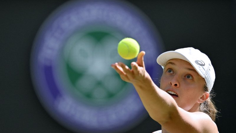Fotografija: (FILES) Poland's Iga Swiatek serves to France's Alize Cornet during their women's singles tennis match on the sixth day of the 2022 Wimbledon Championships at The All England Tennis Club in Wimbledon, southwest London, on July 2, 2022. Iga Swiatek will attempt to add the Wimbledon title to the US and French Open crowns she already possesses when the third major of the season gets underway on July 3, 2023. (Photo by Glyn KIRK/AFP)/RESTRICTED TO EDITORIAL USE Foto Glyn Kirk Afp