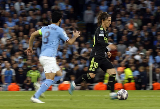 Luka Modrić (desno) in Ilkay Gündogan sta v igri izjemno inteligentna nogometaša. FOTO: Jason Cairnduff/Reuters