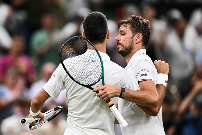 Serbia's Novak Djokovic (L) hugs Switzerland's Stan Wawrinka after winning their men's singles tennis match on the fifth day of the 2023 Wimbledon Championships at The All England Tennis Club in Wimbledon, southwest London, on July 7, 2023. (Photo by SEBASTIEN BOZON/AFP)/RESTRICTED TO EDITORIAL USE Foto Sebastien Bozon Afp