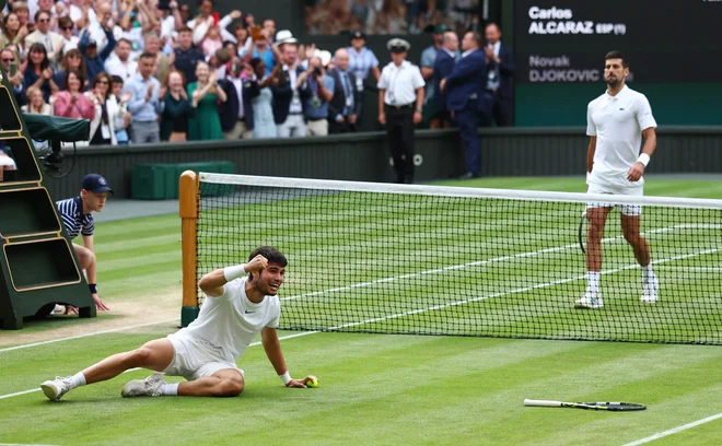 Carlos Alcaraz se je takole razveselil svoje prve lovorike v Wimbledonu. FOTO: Toby Melville/Reuters